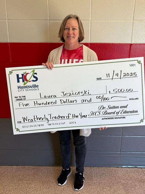 Weatherly Teacher of the Year, Mrs. Jeziorski holds a large ceremonial check for $500 from Huntsville City Schools