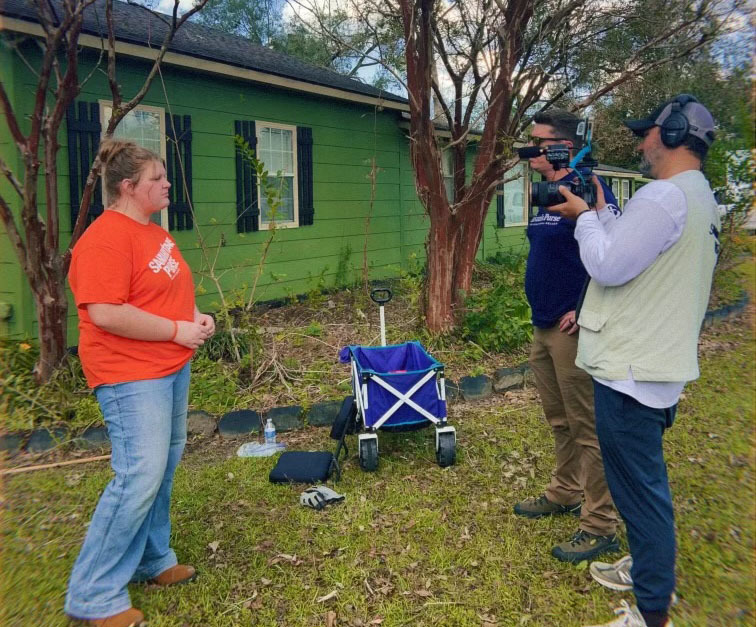 Female student stands in front of the camera for an interview with the press.