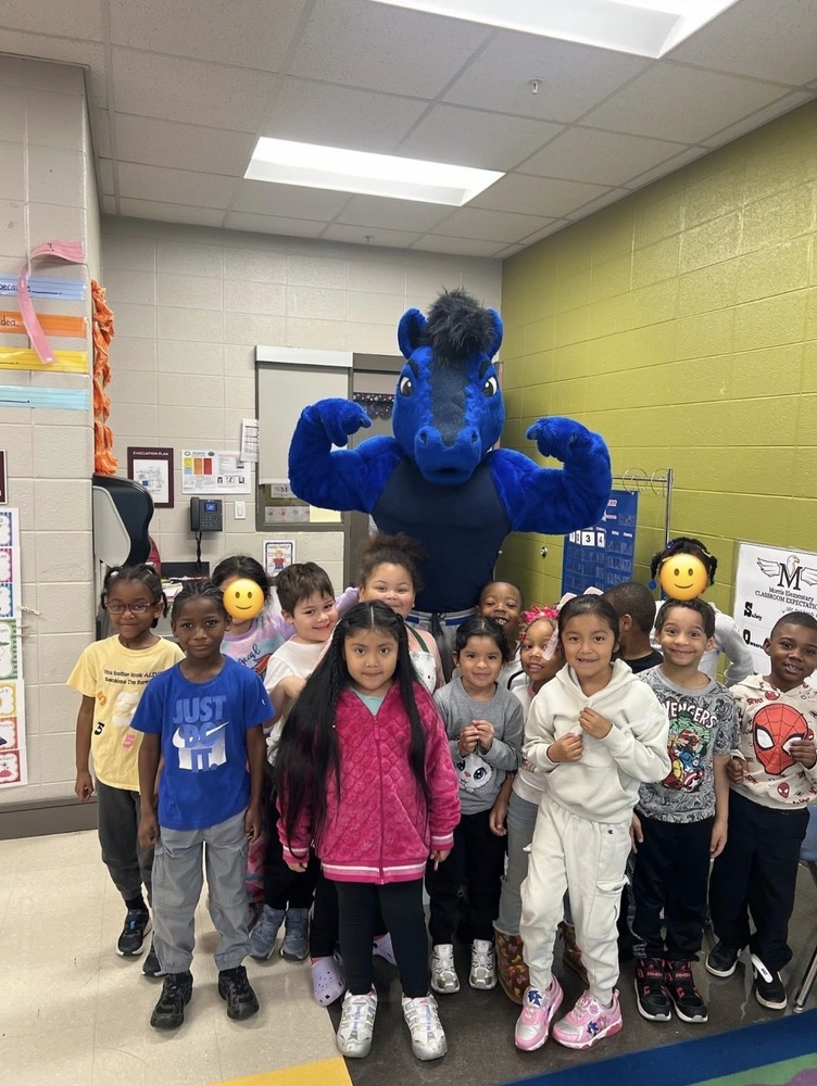 The mascot from UAH posing for a picture with kindergarten students