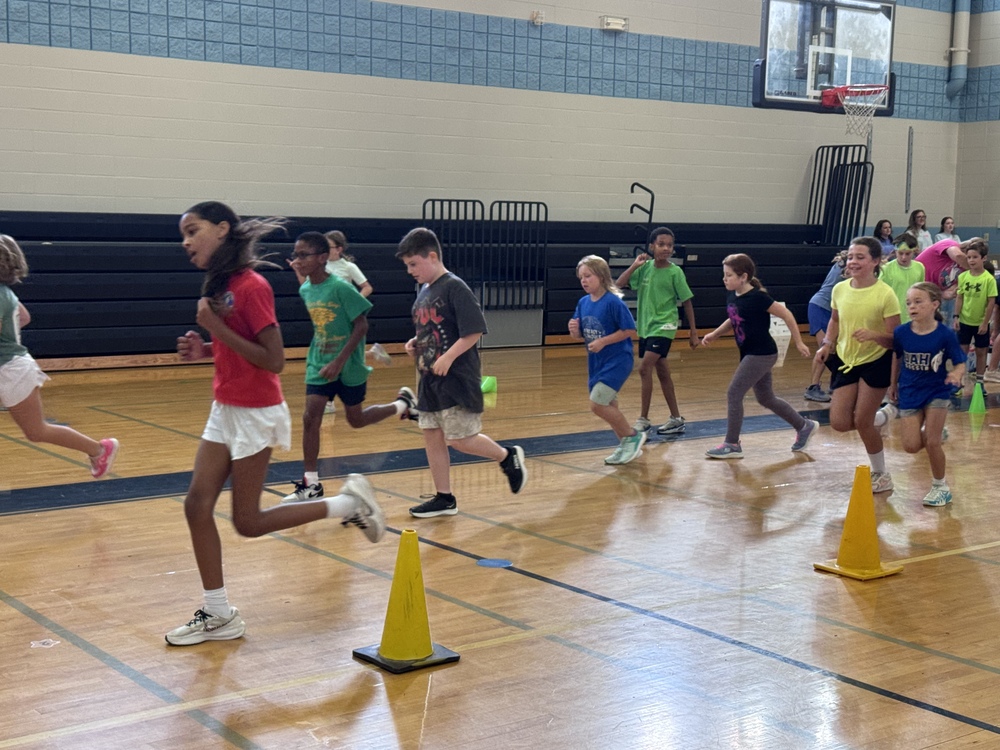 50 4th grade students running in the gym to earn their Boosterthon points