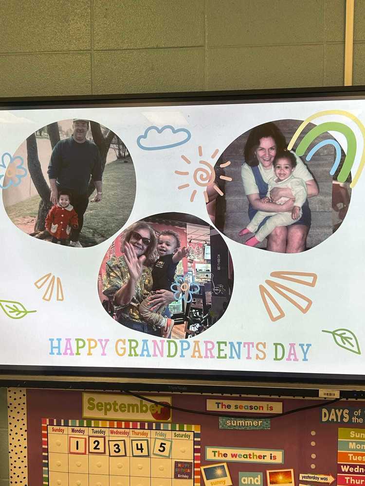 A colorful classroom display at RHES celebrates Grandparents Day, featuring photos of children with their grandparents surrounded by cheerful drawings of flowers, suns, and rainbows.