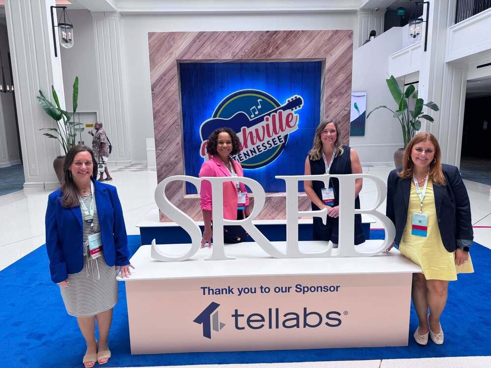 Ms. LeCompte, Mrs. Bardwell, Ms. Folk and Mrs. Formby standing around a table at the conference. The table has big letters SREB on top.