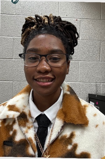 Jaelynn Walker, a Lee High School Creative Writing Magnet senior, smiles for a portrait in a school hallway.