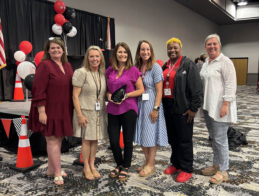 Heather Hall poses with her award alongside HCS educational technology staff and ALSDE representatives