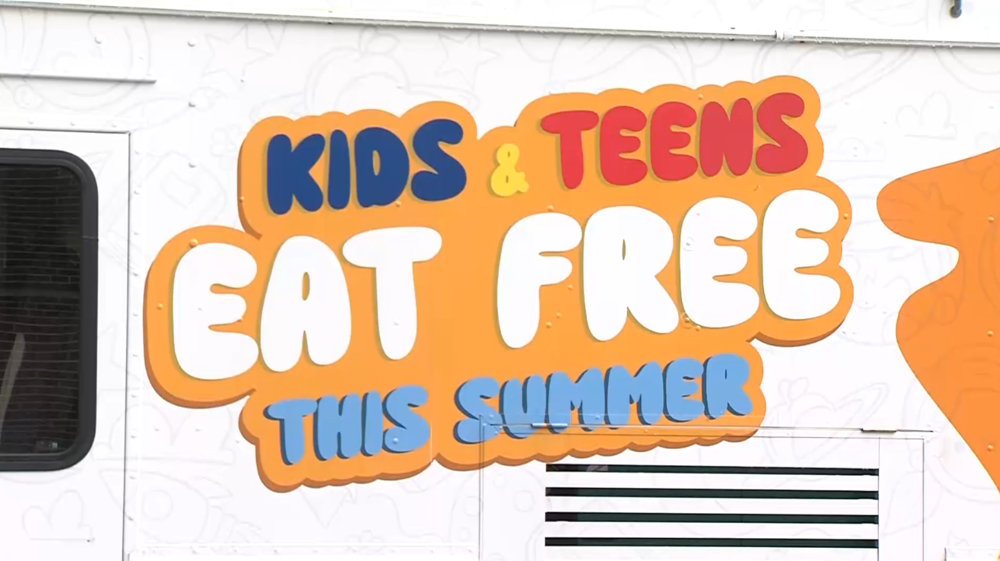 Side of van with text Kids & Teens Eat Free This Summer in large colorful letters