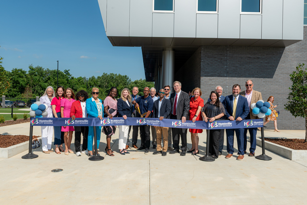 District leaders, past and present, cutting ribbon on new central office and career tech facility
