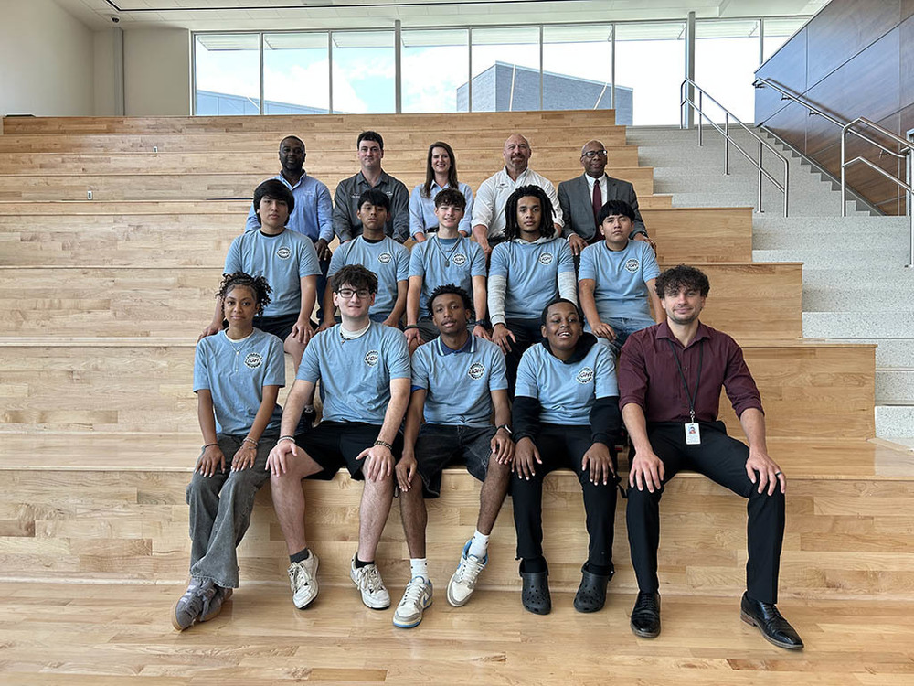 LIGHT Students seated on bleachers with instructors and Dr. Sutton