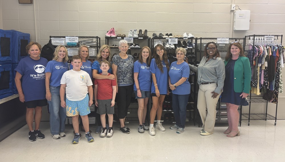 Principal Donna Peavy poses with volunteers from the Caring Link in a Chapman classroom that is not the new Caring Closet.