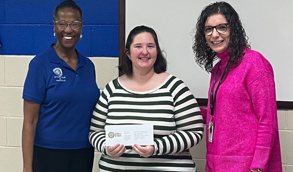 Stephanie Clemons and Dr. Jennifer McKinney accept a check from a member of the Optimist Club of Huntsville.