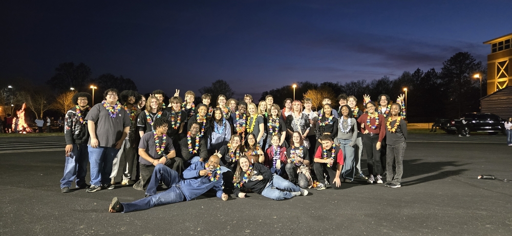 Students pose on the track at the celebratory bonfire.