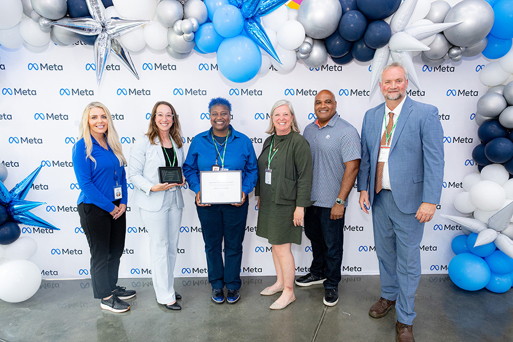 META Employees pose with Rachel Evans, Bonnie Garrett, Elizabeth Fleming, and AJ Buckner to present the Grant Certificate