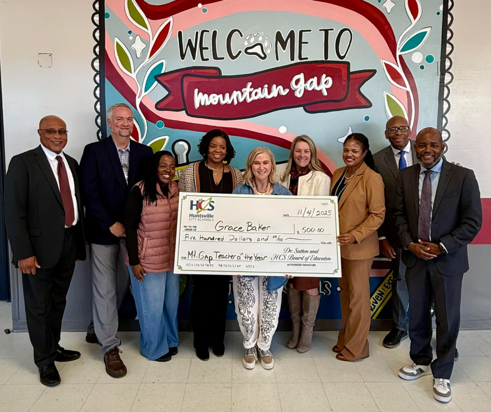 Nine adults presenting Grace Baker with Teacher of the year for Mountain Gap Elementary school