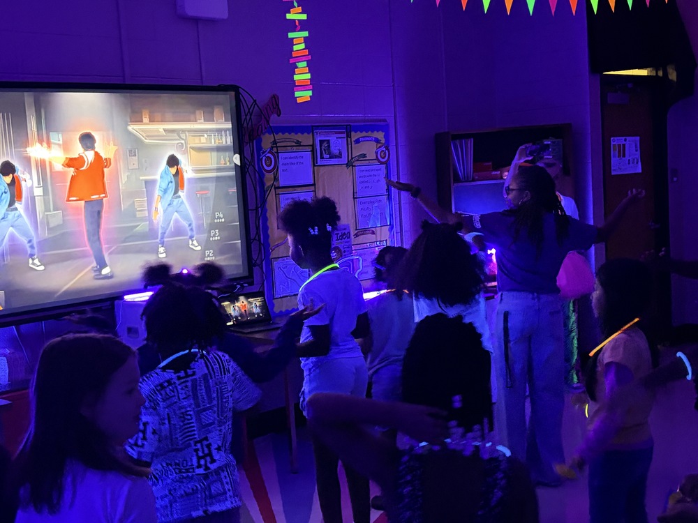 A group of children in a dark room with neon glow lights