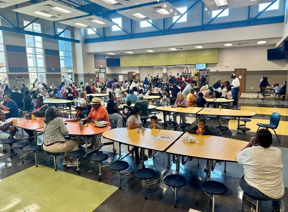 Morris Elementary grandparents, parents, students and teachers sitting in the cafeteria eating breakfast for Grandparents Day.