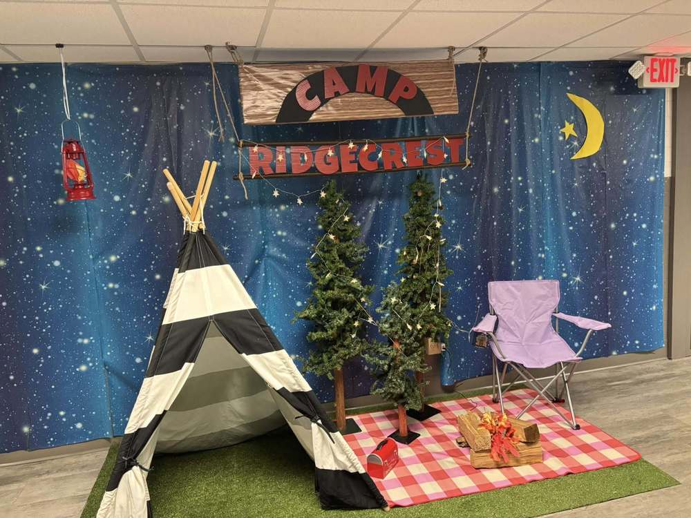Image of display with a tent, camp chair, trees, and a sign that reads Camp Ridgecrest