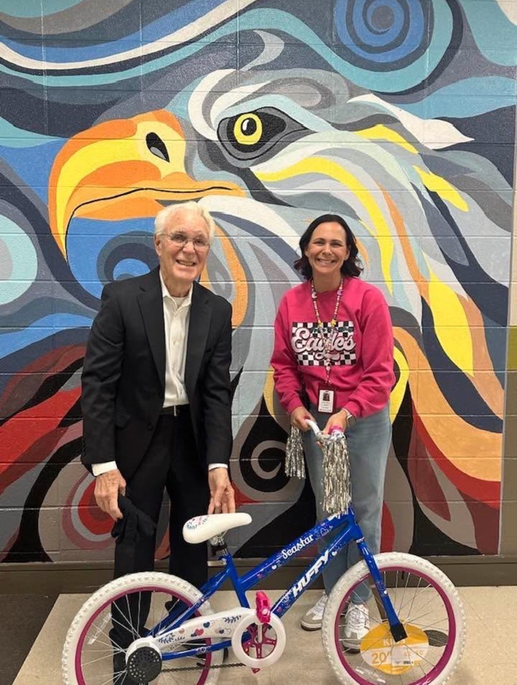Volunteer Mr. Seay and principal Dr. Maples showing the bike that students are competing for.