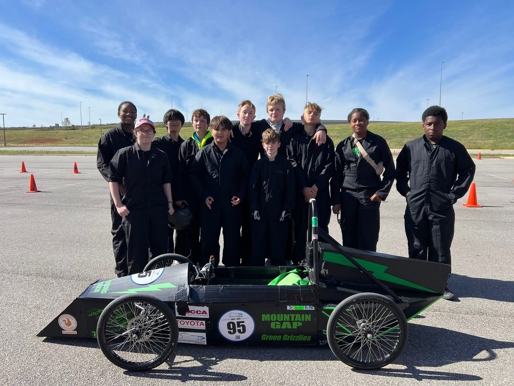 The greenpower team standing behind their car