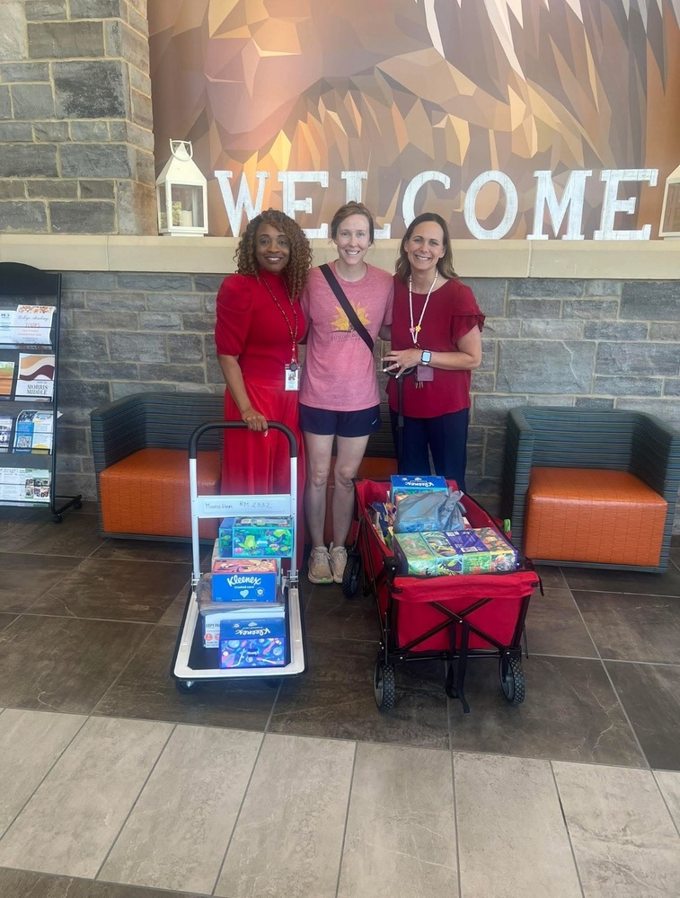 Three women standing in the s2 school lobby