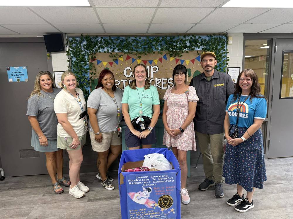 Staff members accepting the donations from Yellowhammer Brewing