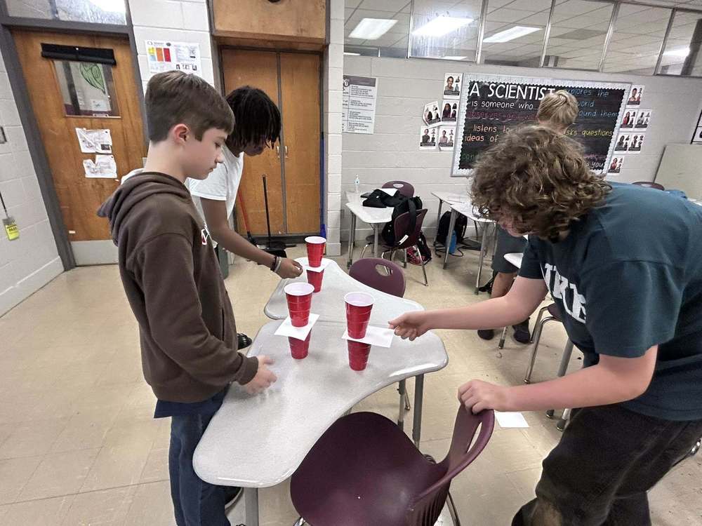 Three students experimenting with inertia towers