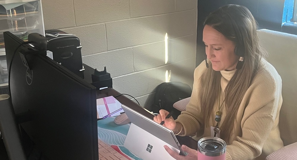 Teacher works out a math problem for online students.
