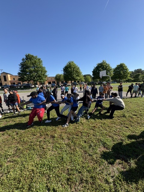 A 6th grade class playing tug-o-war at field day.