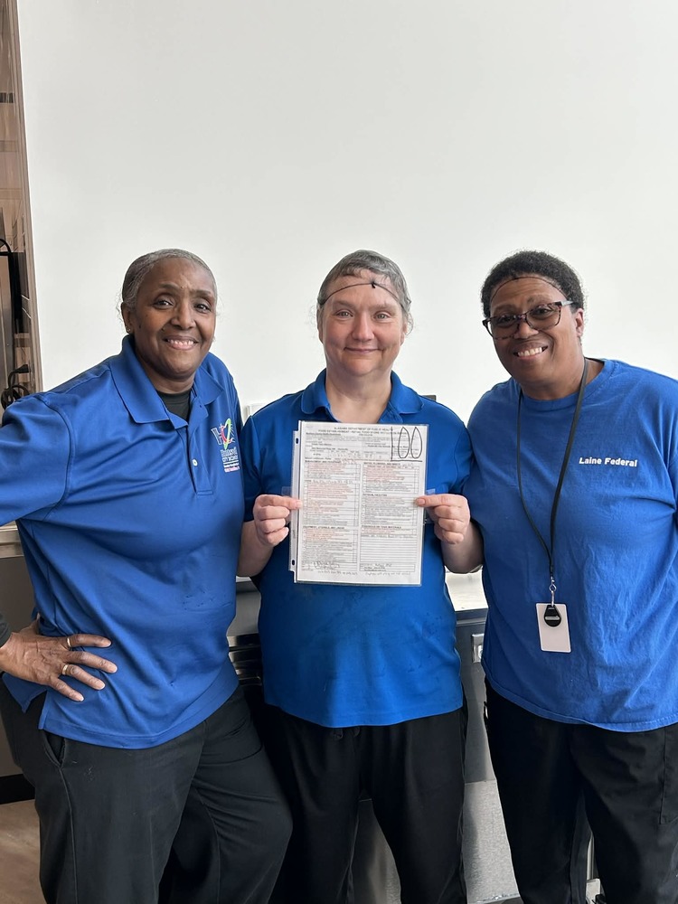 3 members of the Child Nutrition Program pose with a paper showing their 100 health score