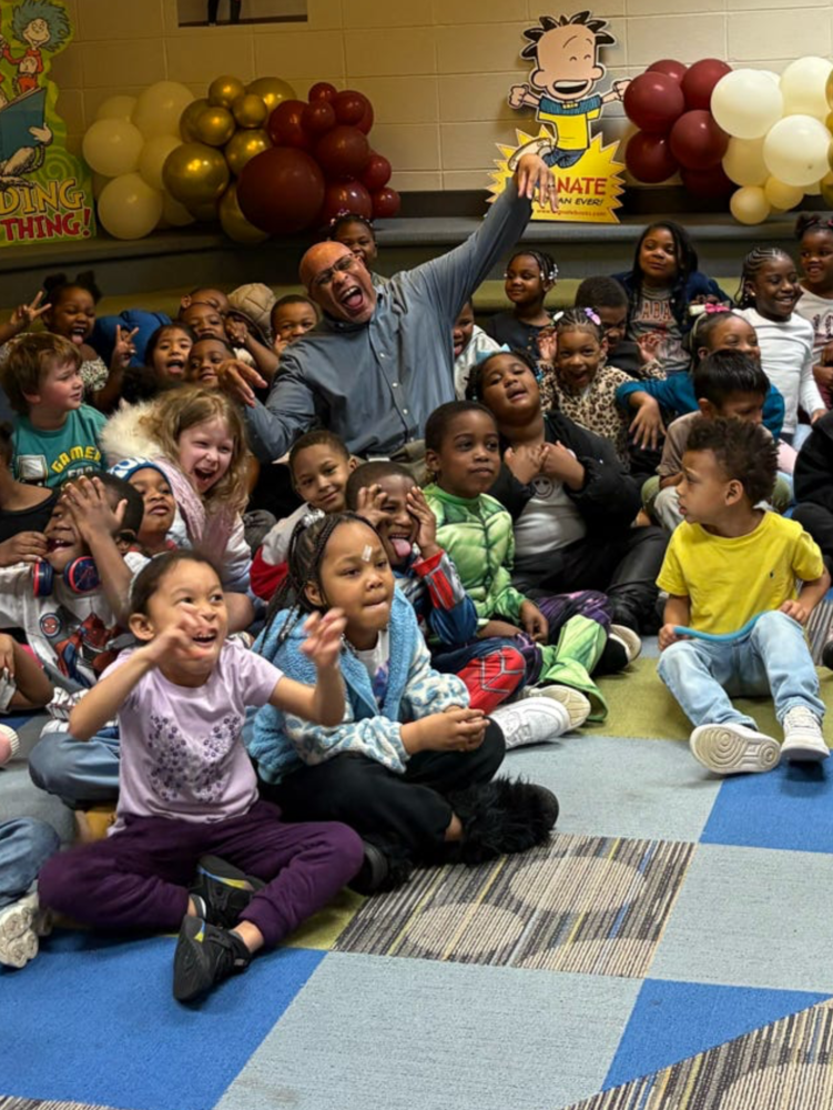Mr. Frederick Barnes sits with kindergarten students during a Read Across America reading activity at Rolling Hills Elementary. 