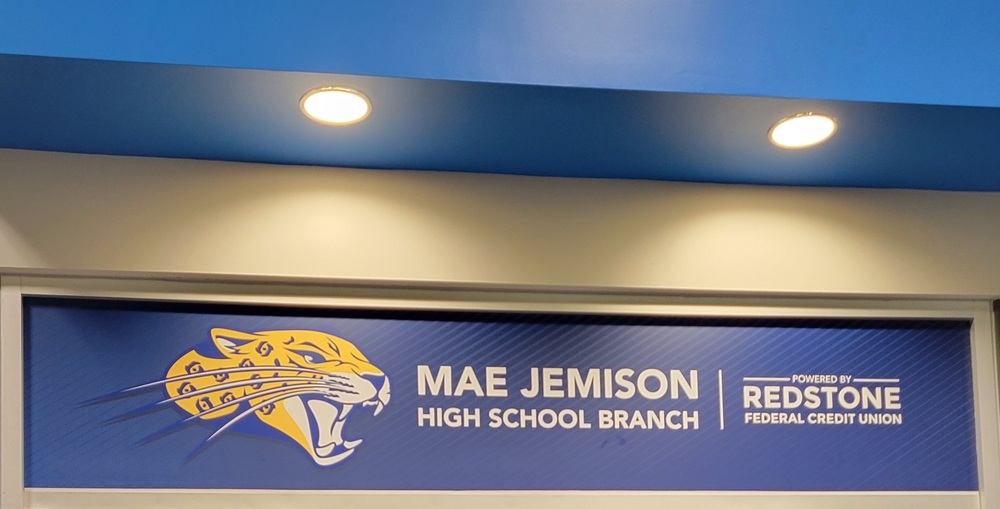 This is a picture of the Mae jemison High School Redstone Federal Credit Union branch sign with the school's jaguar mascot.