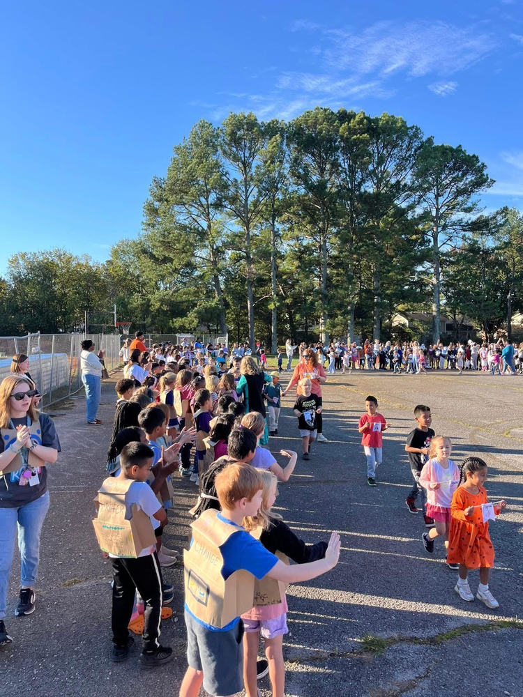 Chaffee Students of all grades standing on the blacktop outside. Students are dressed in their vocabulary parade outfit. Students are parading around the blacktop.