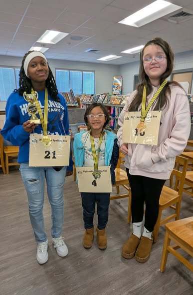 Spelling bee winners smile with medals