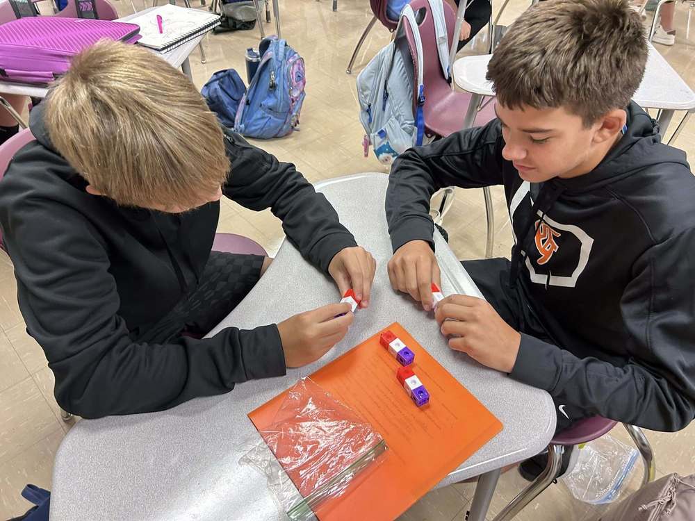 two 8th grade students using building blocks to model pure substances