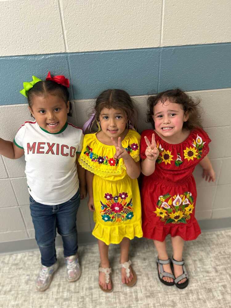 Three students dressed in Hispanic cultural dress