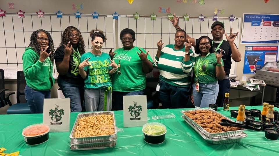 House of Isibindi Members standing in the multipurpose room pictured with wings, fries, 