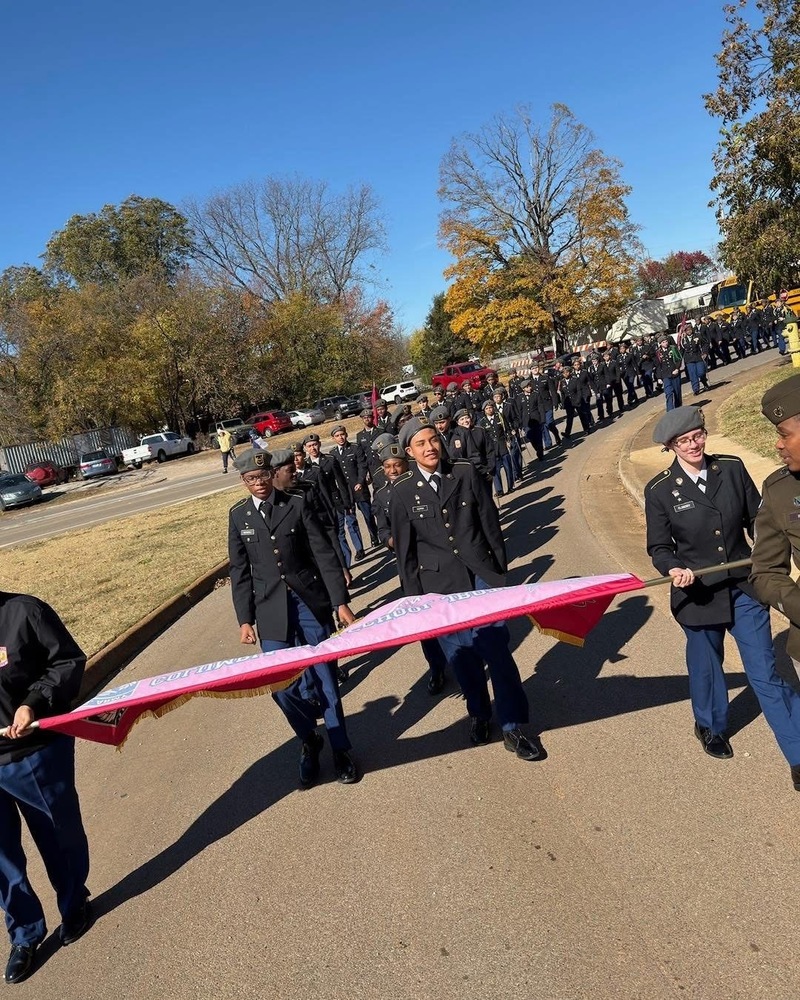 Columbia JROTC Eagle Battalion in Class A uniforms holding flag marching in Vets Day parade in downtown Huntsville