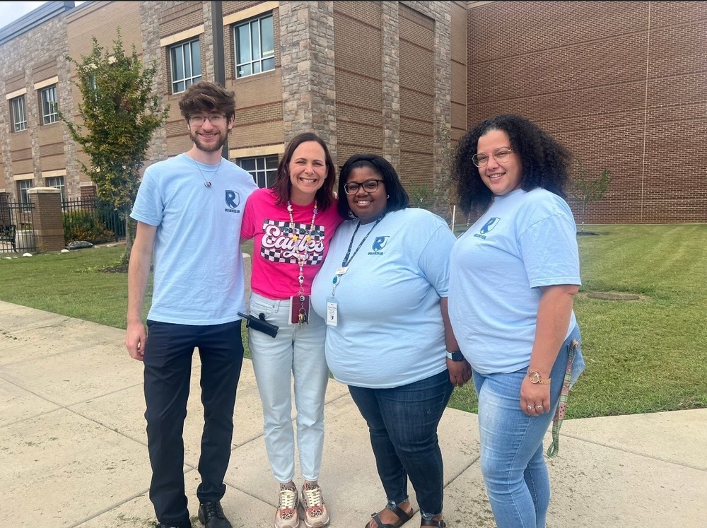 man from Redstone Federal  Credit Union  standing beside the principal and two volunteers from the Redstone Federal Credit Union