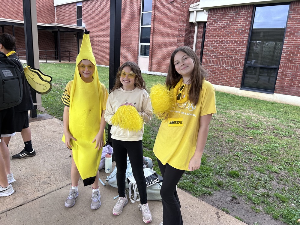 three yellow house students greeting students in the morning
