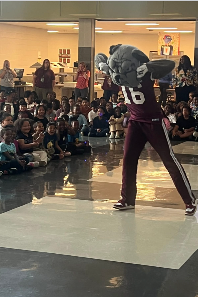 Alabama A&M mascot dancing in front of the elememtary students.
