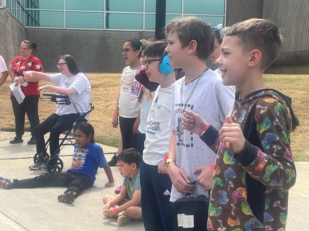 A group of young students look as their rocket is launched.