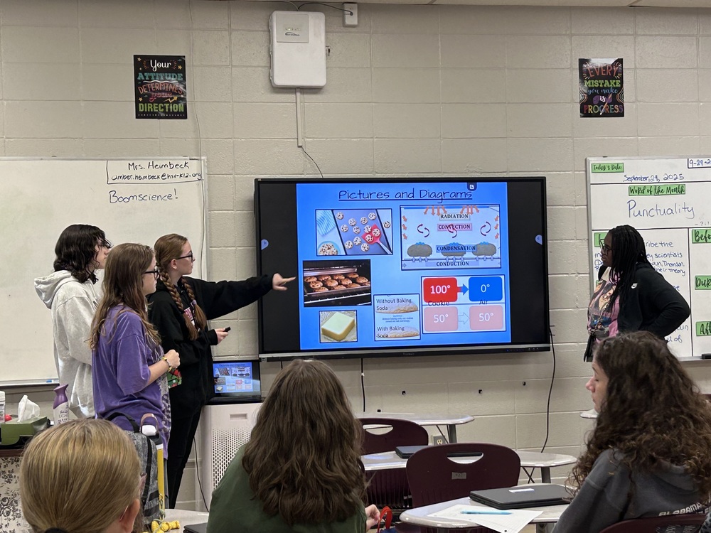 A group of 8th grade students presenting their project in front of a class