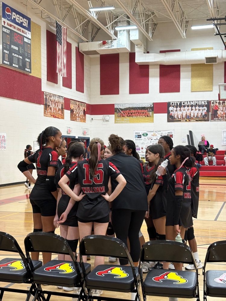 The Williams Middle School volleyball team in a huddle during a game.