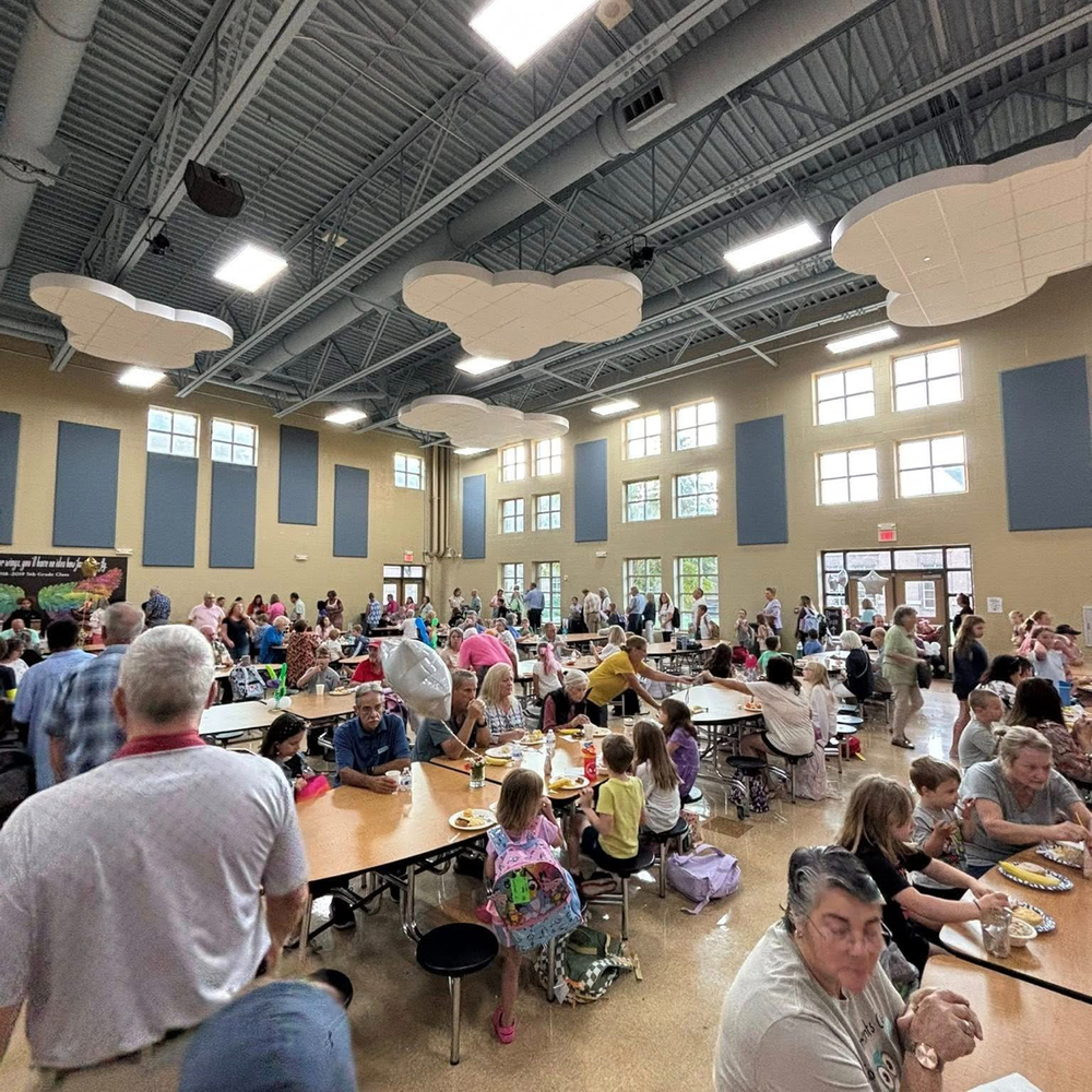 Cafeteria with grandparents and students eating.