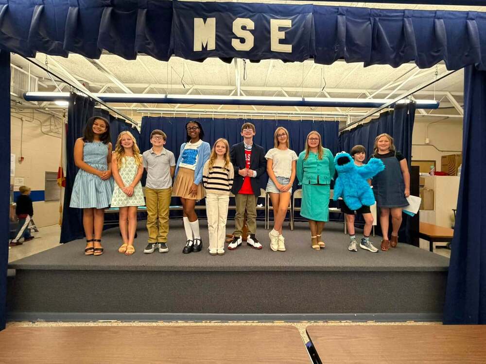 10 students standing on stage