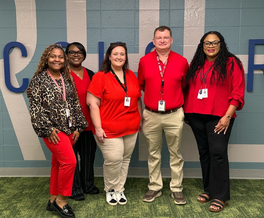 RHES staff pose wearing red in honor of dyslexia awareness