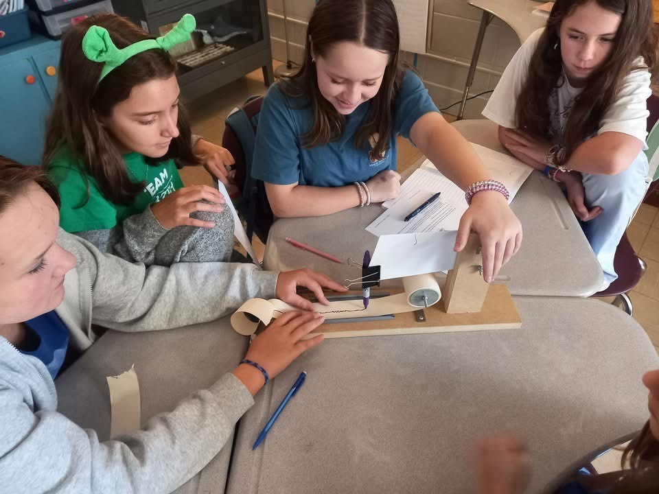 Four 6th grade students experimenting with seismographs