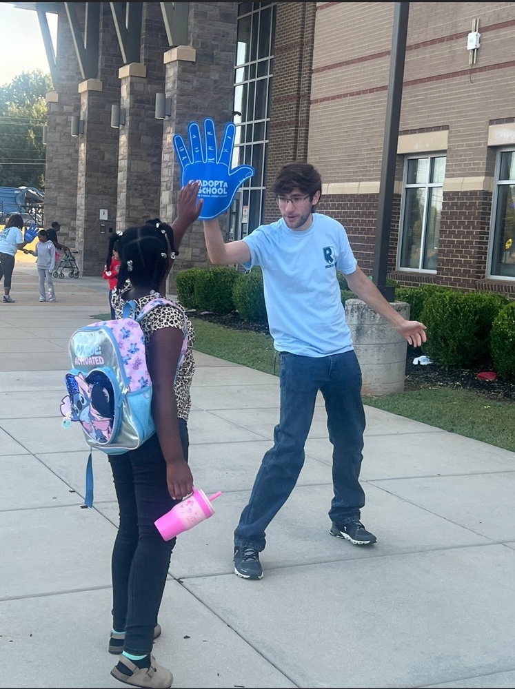 Morris student giving  Redstone Federal Credit Union volunteer a igh five