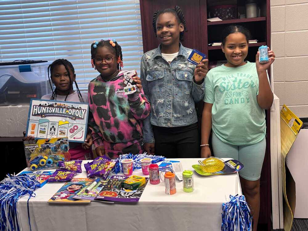 Students hold up prizes that they were awarded for attendance day.