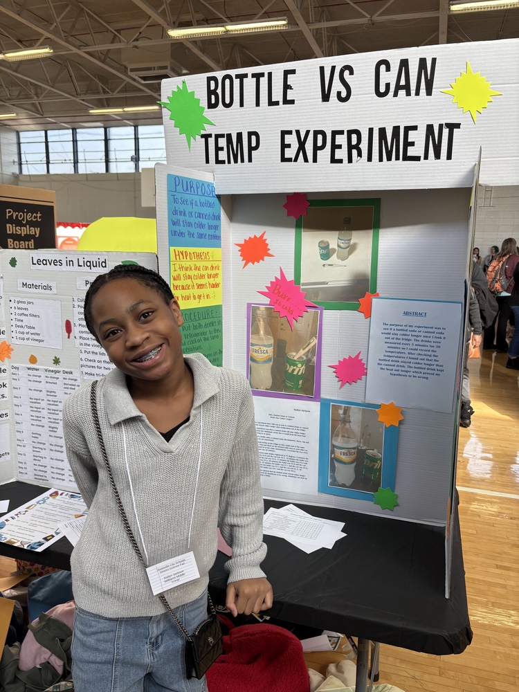 Kailyn Jackson standing in front of her science fair project board at the district science fair at ASFL. 