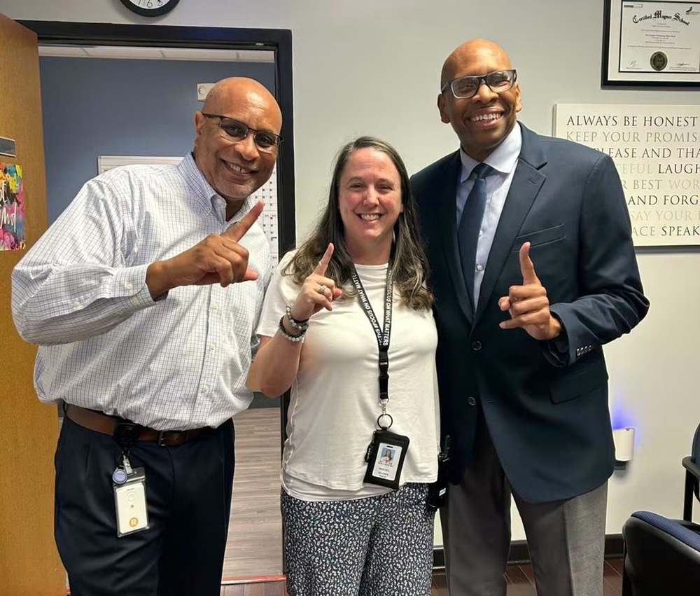 Principal White, Dr. Sutton, and Mr. Barnes making the #1 symbol with their hands