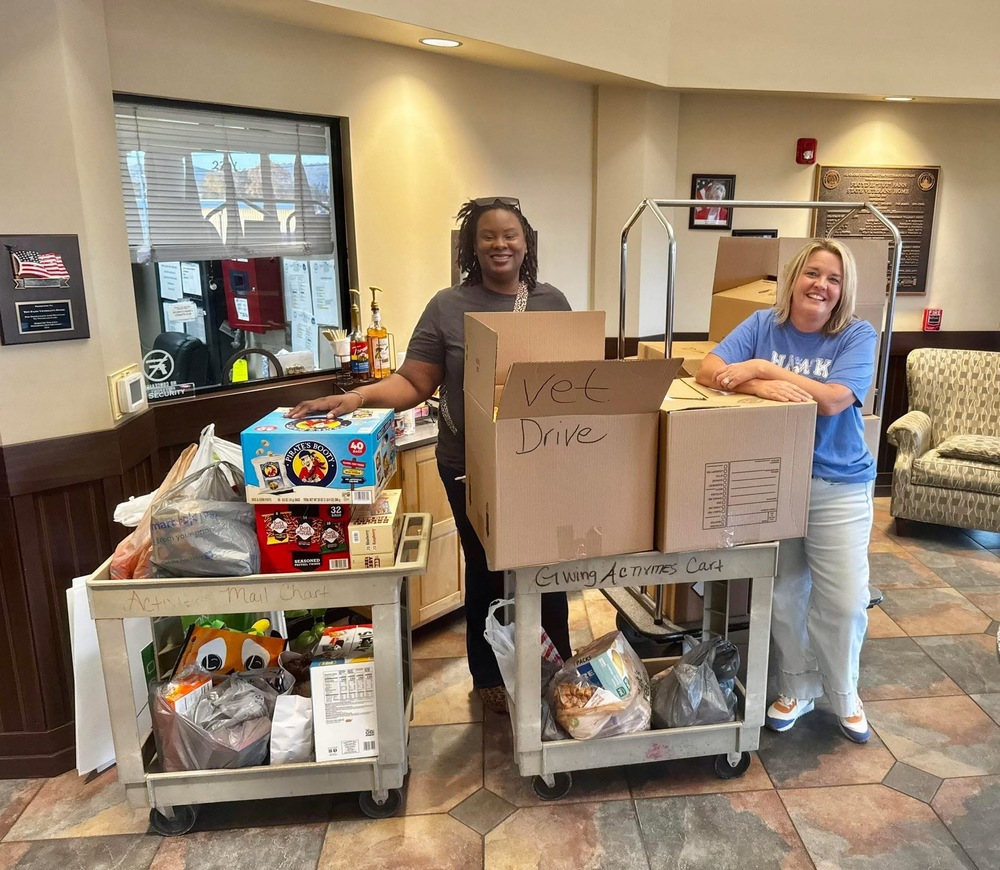 Dr. Perkins and Mrs. Rehome with carts of food donations for the Tut Fann Veterans Home